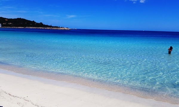 Spiaggia La Cinta vista dal gommone con Tavolara sullo sfondo e mare turchese